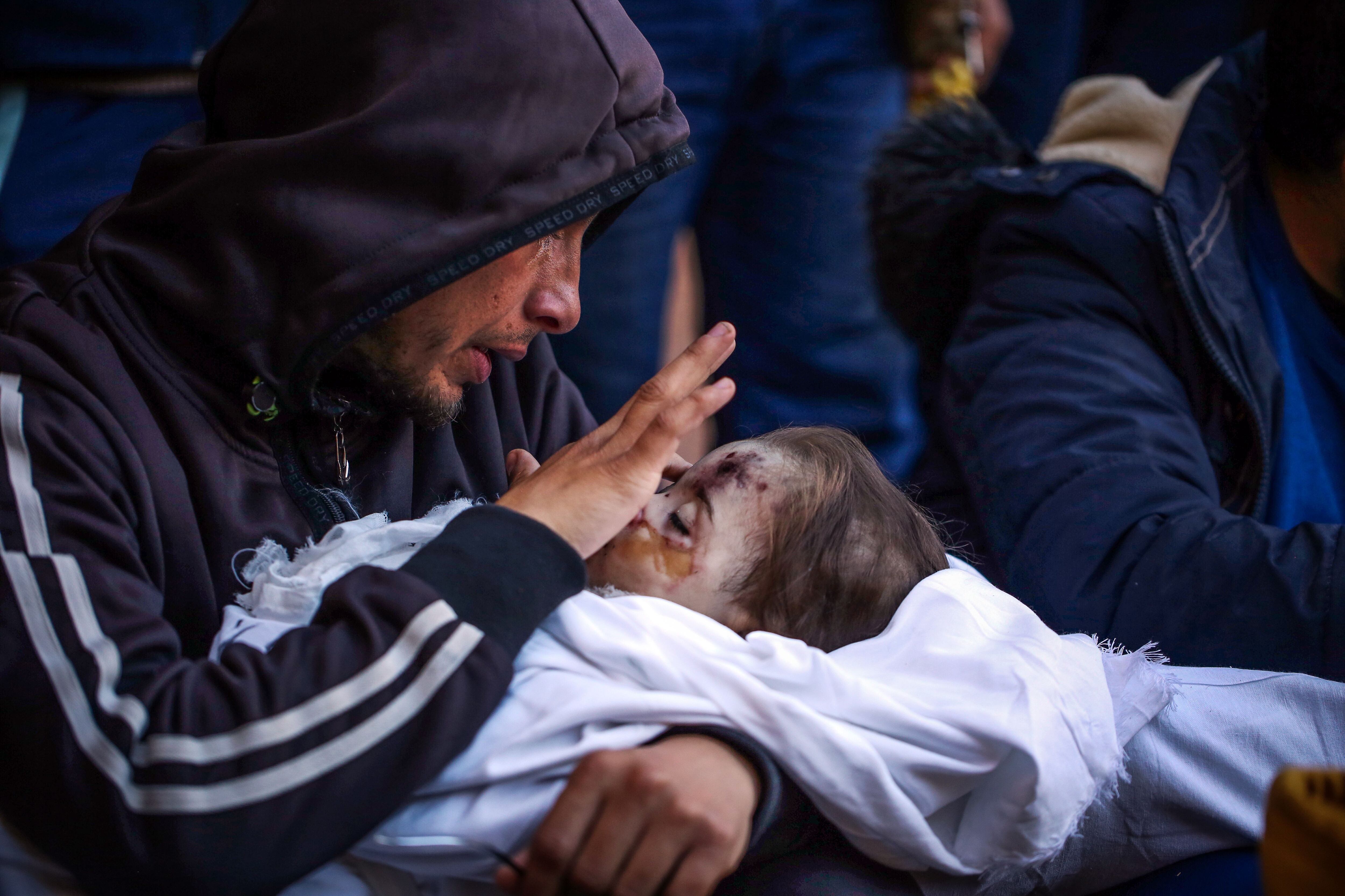 A man holds the corpse of a little girl in Nasser Hospital, Gaza Strip, January 7, 2024.