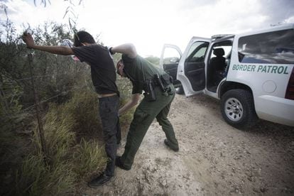 A border control agent searches an undocumented immigrant in Roma, Texas.