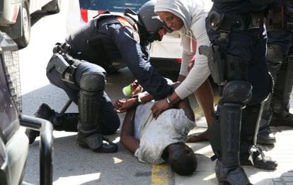 Catalan officers arrest a man following a riot in Salou.