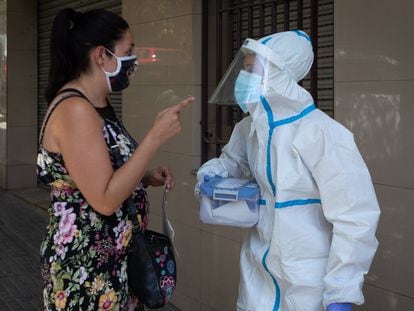 A woman speaks with a health worker in Ripollet, in Barcelona province, where the Catalan region government has begun a mass Covi-19 testing campaign.