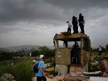 Israeli settlers stand in the outpost of Eviatar in the West Bank, on April 10, 2023.