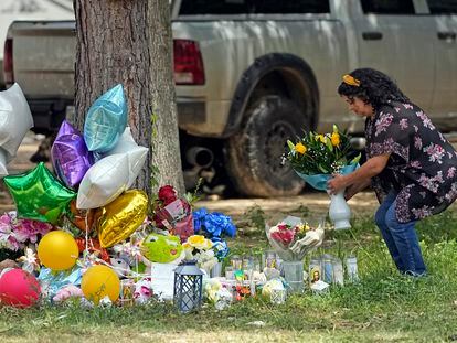 A woman places flowers Tuesday, May 2, 2023, outside the home where a mass shooting occurred Friday, in Cleveland, Texas.