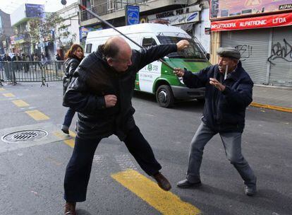 A Pinochet supporter is attacked by a demonstrator Sunday in Santiago.