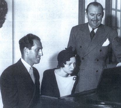 Dana Suesse seated at a piano flanked by George Gershwin (left) and Paul Whiteman