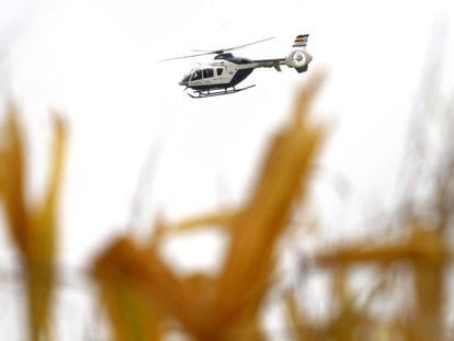 A police helicopter flies over the countryside around El Salobral.