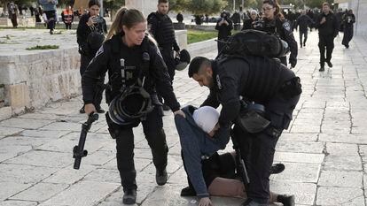 Israeli police arrest a Palestinian woman at the Al-Aqsa Mosque compound following a raid at the site in the Old City of Jerusalem during the Muslim holy month of Ramadan, Wednesday, April 5, 2023.