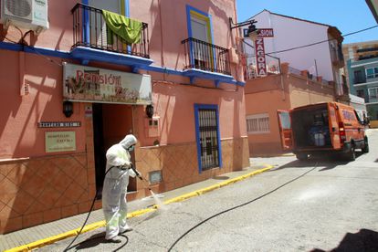 An Algeciras city worker disinfects the outside of a hostel following a coronavirus outbreak.