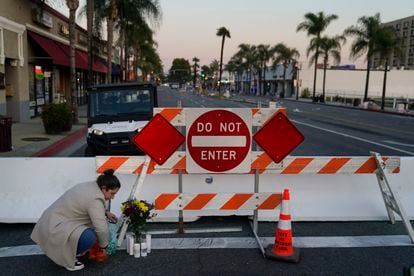 Stephanie Kozofsky, 31, leaves flowers and candles to honor the victims killed in Saturday's ballroom dance studio shooting in Monterey Park, Calif., Sunday, Jan. 22, 2023.