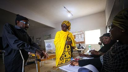 Two voters cast ballots in the presidential elections in Senegal, at a polling station in the capital of Dakar, on March 24, 2024.