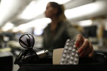A woman pulls lorazepam pills from her purse.