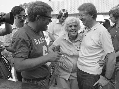 Lillian Carter is flanked by her sons Jimmy, right, and Billy as she met them down at Billy's gas station, where the Carters and neighbors cleaned fish prior to a town cookout, June 26, 1976.