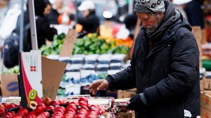 A man looks over produce for sale on display at an outdoor market at an outdoor market in Boston, Massachusetts, on March 15, 2024.
