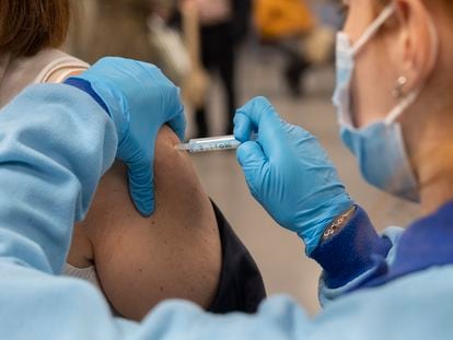 A health worker administers a third Covid-19 vaccine shot in Seville.