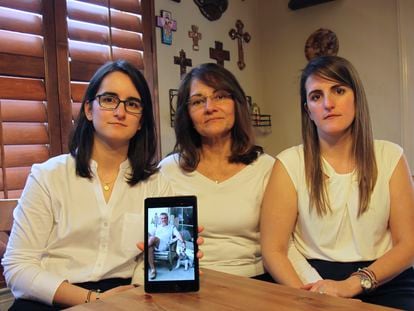 Dennysse Vadell sits between her daughters Veronica, right, and Cristina, Feb. 15, 2019, in Katy, Texas, while holding a digital photo of father and husband Tomeu Vandell, who was jailed in Venezuela at the time.