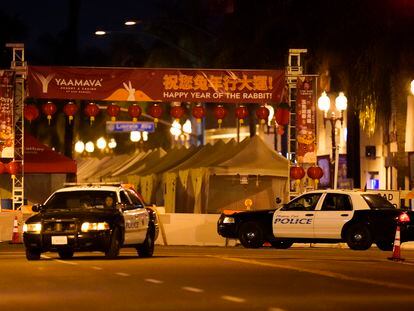 Two police vehicles are seen near a building where a shooting occurred in Monterey Park, Calif., Sunday, Jan. 22, 2023.
