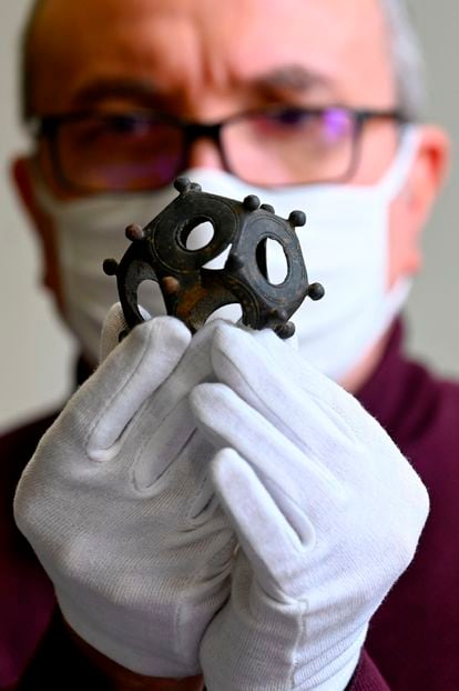 A French researcher holds a Roman dodecahedron found in Metz, eastern France, in December 2020.