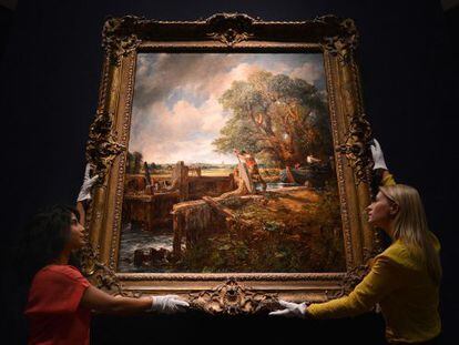 Two Christie&rsquo;s employees hold up John Constable&rsquo;s The Lock, which was sold on Tuesday.  