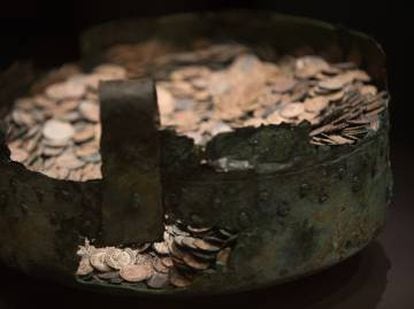 The restored cauldron and Roman coins.