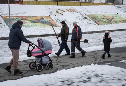 People in Kyiv walk past an exhibition of Russian propaganda posters from liberated Kherson, November 22, 2022. 