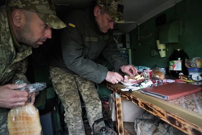 Lt. Volodymyr (right), who commands a Grad rocket company, prepares food while he waits for orders to attack in Chasiv Yar on the Bakhmut front. 