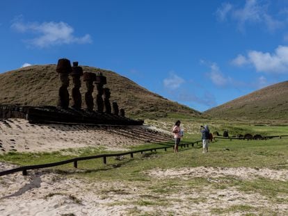 Two tourists are photographed in front of the moais of Anakena, on Easter Island, on August 5.
