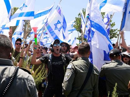 Protesters wave the flag of Israel during a demonstration near the Knesset, Israel's parliament, in Jerusalem on July 24, 2023.