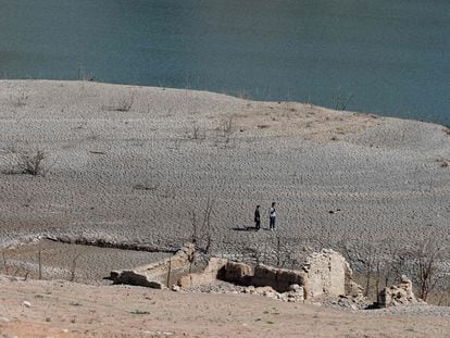 Two people walk through the Sau reservoir, in Girona, on April 16, 2023.