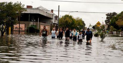 Residents wade through floodwater after heavy rains in La Plata on Wednesday.