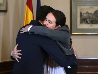 Pedro Sánchez and Pablo Iglesias embrace after signing their agreement on Tuesday.
