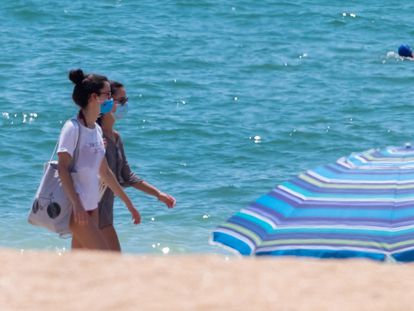 Beachgoers wearing face masks on the beach in La Antilla, in Andalusia's Huelva province.