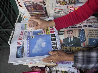 A business owner weights down copies of the 'Chinese Daily News' newspaper showcasing pictures of a suspected Chinese spy balloon, in the Chinatown district of Los Angeles Sunday, Feb. 5, 2023.