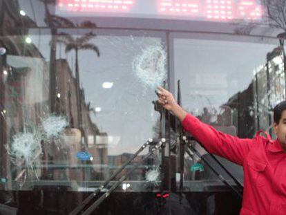 Maduro pointing to buses vandalized during the protests.