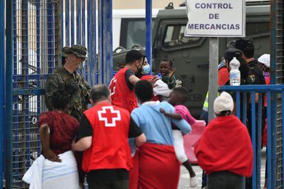 Red Cross members help several women and children as they arrive in Ceuta on Wednesday.