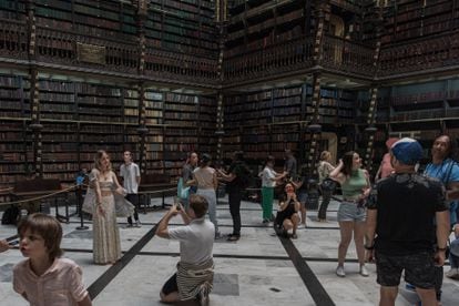 Visitantes e turistas fotografam o salão principal do Real Gabinete Português de Leitura. 
