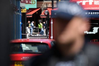 Police officers look for evidence at an attack site in London.