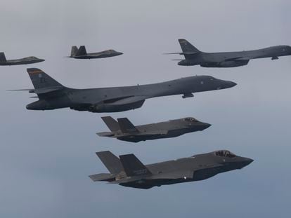 In this photo provided by South Korean Defense Ministry, US Air Force B-1B bombers, center, F-22 fighter jets and South Korean Air Force F-35 fighter jets, bottom, fly over South Korea Peninsula.