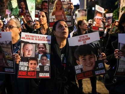 A woman holds portraits of hostages Erez Kalderon, 12, and of children of the Goldstein Almog family as protesters rally outside the Unicef offices in Tel Aviv on November 20, 2023.