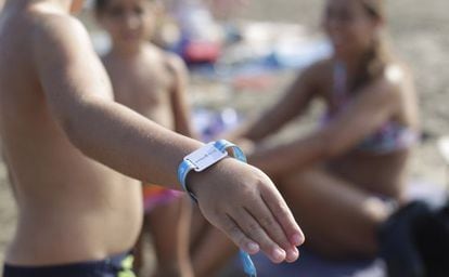 A child shows off his bracelet at a beach in Castellón.