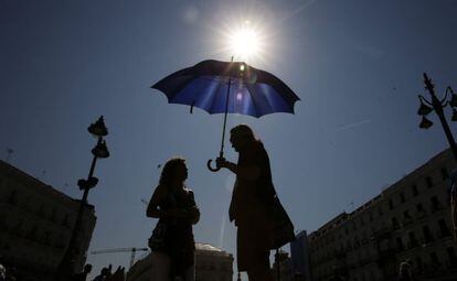Tourists protect themselves from the heat in Puerta del Sol in downtown Madrid.