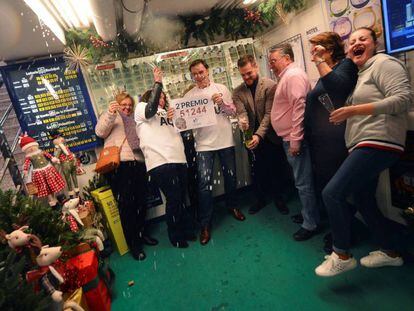 A lottery shop celebrates having sold the second-prize winning number