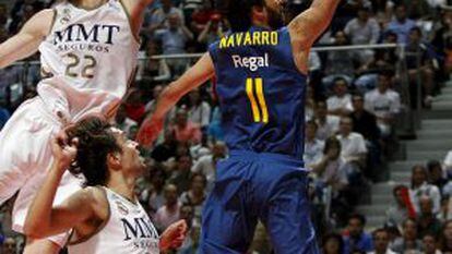 Real Madrid&acute;s Kyle Singler (l) and Sergio Llull (c) try to prevent Barcelona&#039;s Juan Carlos Navarro from scoring.
