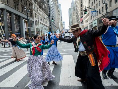 Marchers dance together down New York's 5th Avenue in traditional costumes during the 55th Hispanic Day Parade, on October 13, 2019.