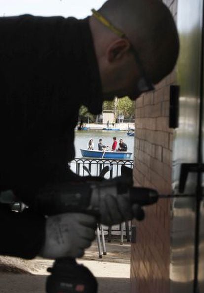 A municipal workman breaks the lock to the door of a quiosco before padlocking it shut.