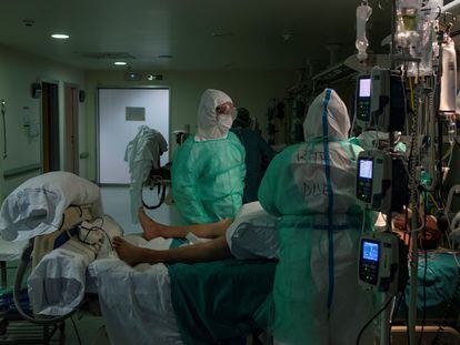 Healthcare workers in Spain help a Covid-19 patient in an intensive care unit.