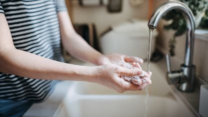 A person washes their hands.