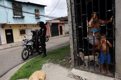 Guayaquil residents look on while police set up a
 roadblock on Friday. 