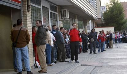People line up outside an employment office in Madrid to file jobless claims.