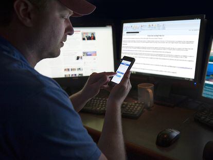 A man checks Facebook on his cellphone.