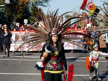 A woman wearing Native American clothing attends a "No Honor in Racism Rally" march in front of TCF Bank Stadium before an NFL football game between the Minnesota Vikings and the Kansas City Chiefs, Oct. 18, 2015, in Minneapolis.