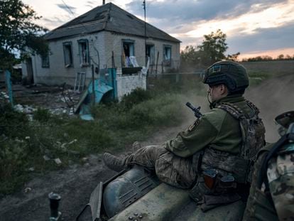 A Ukrainian soldier rides atop an APC on the frontline in the Luhansk region, Ukraine, on May 21, 2023.